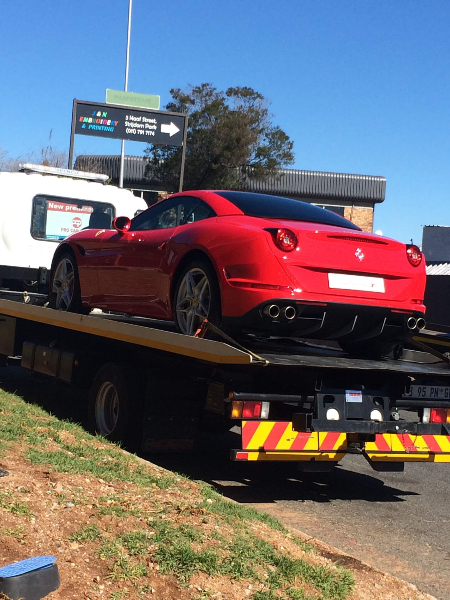 A red sports car carefully loaded onto an Autohaus flatbed