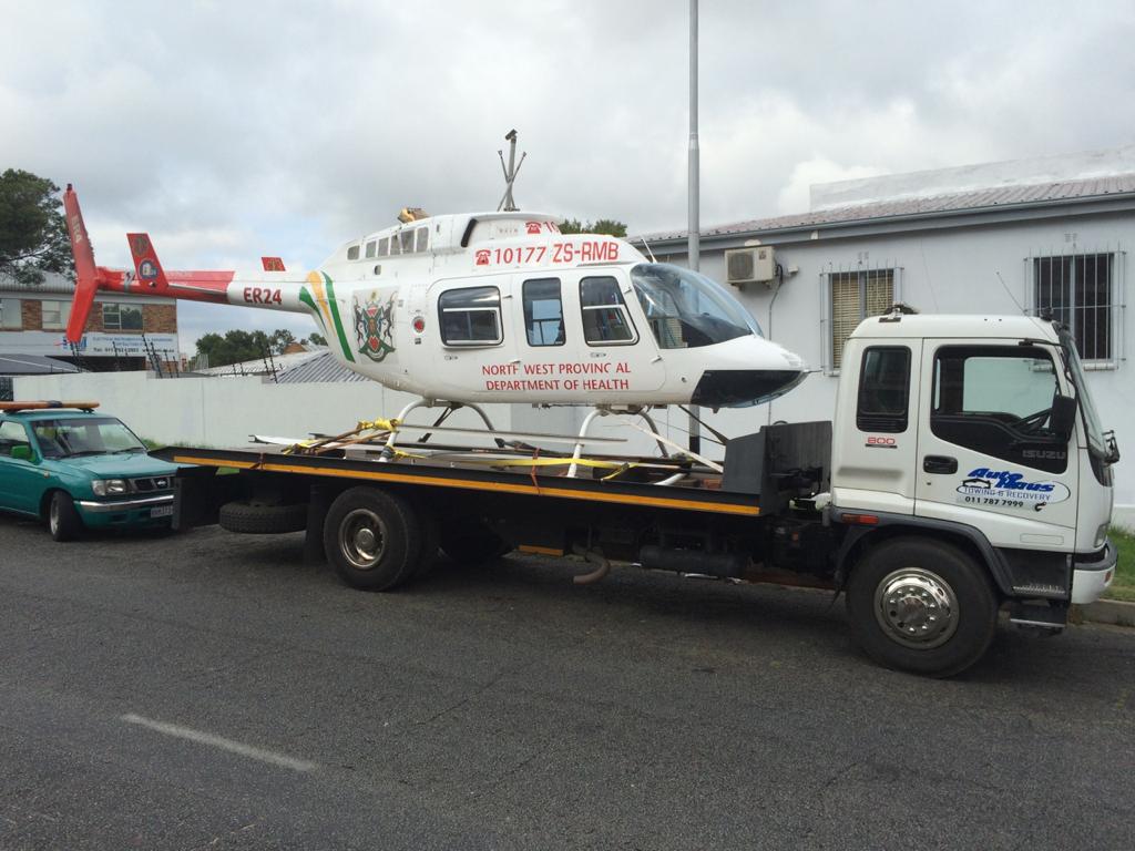 Autohaus flatbed tow truck transporting an ER24 rescue helicopter